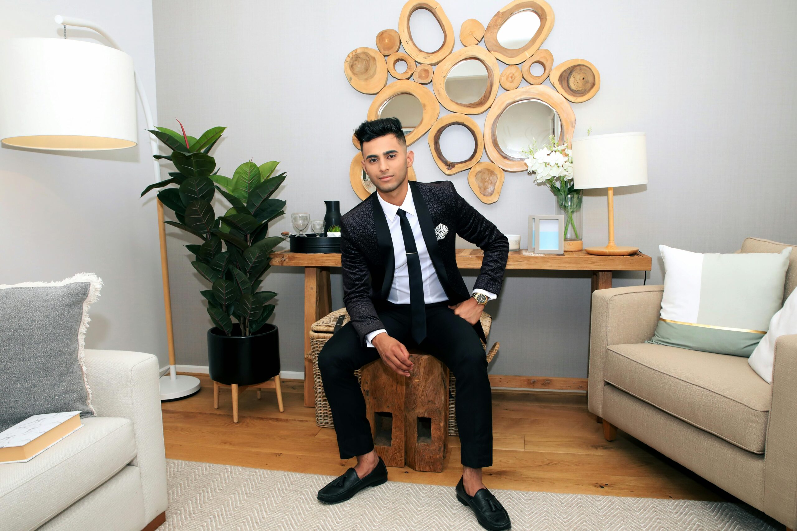 Dapper young man in a chic living room, showcasing contemporary interior design with stylish decor.