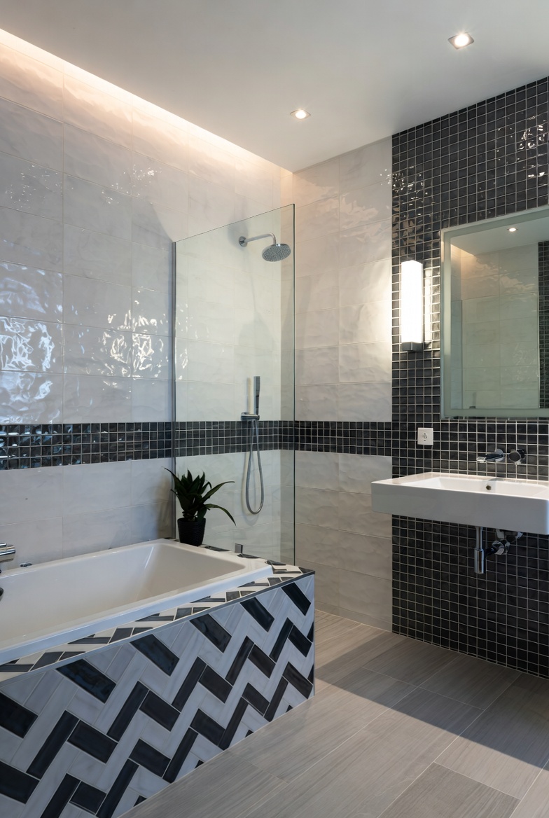 A modern bathroom interior showcasing a stunning bathroom tiles design with elegant mixed tile textures, ambient lighting, and stylish fixtures, perfect for home renovation inspiration.
