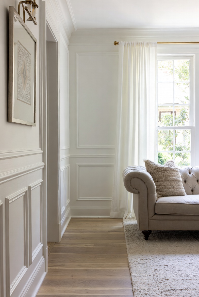 A beautifully styled living room showcasing a variety of creative wall designs including wainscoting, wood panels, and gallery walls, representing the best living room wall designs to transform your space.