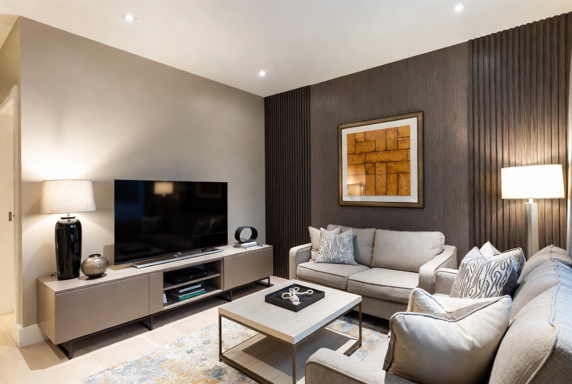 A beautifully styled modern living room showcasing a bold accent wall design with layered decor, neutral toned furniture, and warm ambient lighting, illustrating creative living room wall designs that transform any space.