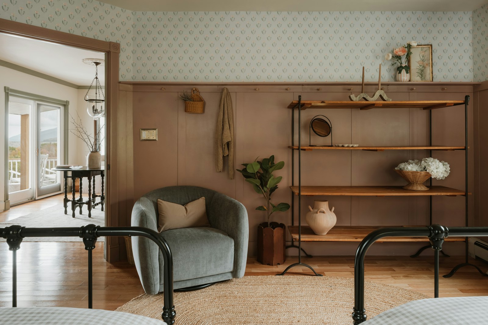 Small bedroom decorated with a wall-mounted floating shelf, armchair, and mirror to create visual space